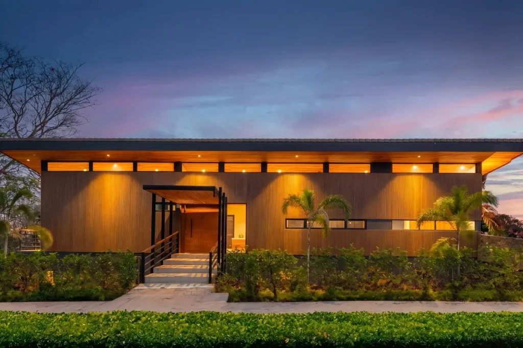 Modern wood-clad home lit at dusk in Senderos, Tamarindo, Costa Rica